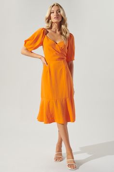 Dare to be the boldest in the room in this fun-loving vibrant dress. Whether you're headed to a casual outing or something more semi formal, this dress is your new go-to. Features generous puff sleeves to frame a surplice neckline. A button snap closure is added along the neckline to ensure security. The bodice maintains a shapely fit, while the skirt widens towards the hem. Pair the look with pops of blues or rattan accessories. - Surplice- Button snap closure- Lightweight- Waist tie- Color: Or Bright Orange Casual Dress, Orange Dress Ideas, Affordable Orange Workwear Dresses, Orange Puff Sleeve Dress For Summer, Chic Orange Short Sleeve Dress, Spring Orange Mini Dress With Puff Sleeves, Casual Orange Puff Sleeve Dress, Orange Summer Dress With 3/4 Sleeve, Vibrant Dress