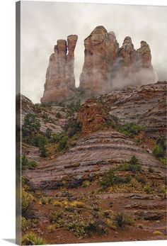 the rock formations are covered in mist and fog as they sit on top of a hill