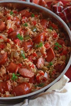 a pan filled with rice and sausage on top of a table