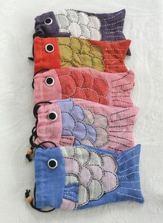 five different colored fish bags on a white table cloth with eyeballs in the middle