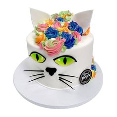 a white cat cake with colorful flowers on top