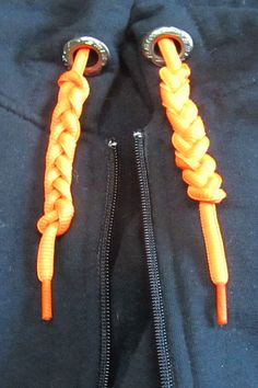 an orange and black jacket with two zippers