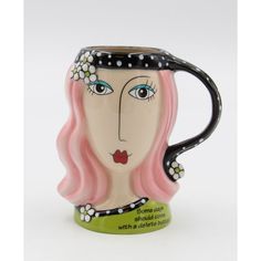 a ceramic mug with a woman's face painted on it