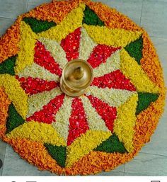 a colorful flower arrangement on the floor with a metal candle holder in front of it