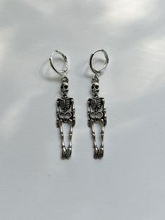 Silver skeleton dangle earrings/huggies Charm size: 9x39mm Charm material: Zinc metal alloy (lead and nickel free) Available with: Nickel free iron metal fish hook earrings: $4.99 14mm Hypoallergenic tarnish resistant silver plated brass huggie earrings: $5.99 Jewelry Care: To ensure maximum life for your new jewels, please avoid doing these things while wearing them, for they will speed up the tarnishing process.  Avoid the 5 S's  - Showering - Swimming - Sleeping - Sprays - Sweating Connect wi Slytherin Outfit, Earrings Huggies, Spooky Earrings, Skeleton Earrings, Jewelry Halloween, Metal Fish, Indie Jewelry, Earrings Halloween, Fish Hook Earrings