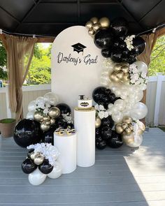 black and white balloons are on display under a tent