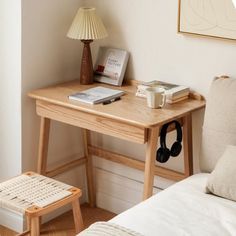 a small wooden table with books and headphones on it next to a couch in a living room