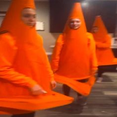 some people in orange costumes are walking around