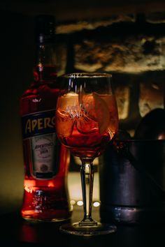 a glass filled with liquid next to a bottle