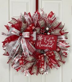 a red and silver christmas wreath hanging on a door