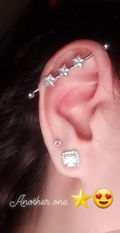 an ear with three different piercings on the top and one is in the middle