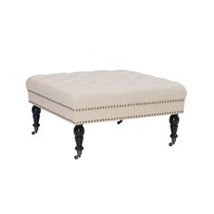 the foot stool is upholstered with black legs and buttons on an off - white fabric