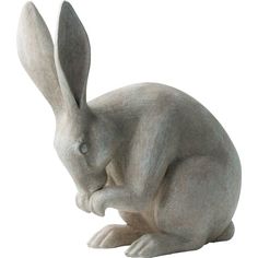 a statue of a rabbit sitting on the ground with its head down and eyes closed