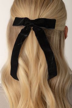 a woman with long blonde hair wearing a black bow