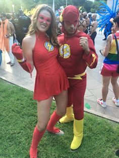 two people dressed up in costumes posing for a photo on the grass at a carnival