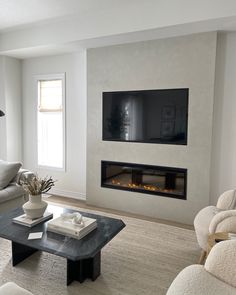 a living room with couches and a television mounted on the wall over a fireplace