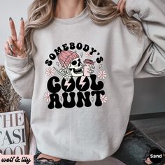 Get ready to be OBSESSED with your new 'Somebody's Cool Aunt' sweatshirt. It's the cutest and most trendy way to emit all those important Auntie vibes! This is the perfect Aunt sweatshirt! Great as an Auntie gift! * Q U I C K * F A C T S * ✺ 50/50 cotton polyester blend - so soft it feels like a cloud on your skin! ✺ Machine wash cold, inside out. Tumble dry low or hang to dry. Do not bleach, iron or dry clean. * S I Z I N G * ✺ Models are wearing XL for the oversized look ✺ Sizing is unisex so runs like men's, though not overly large ✺ Most women find their typical size works best for a more fitted look, since they are meant to fit a touch loose ✺ For the trendy oversized look, we recommend sizing up 1-2 sizes from your normal size ✺ Size guide and fit: See photos * P R O D U C T I O N * Cool Cotton Winter Tops, Cool Cotton Tops For Winter, Cool Crew Neck Tops For Winter, Cool Sweatshirt With Letter Print, Cool Crew Neck Winter Sweatshirt, Cool Long Sleeve Cotton Tops, Trendy Winter Tops With Comfortable Fit, Trendy Comfortable Fit Tops For Winter, Trendy Comfortable Winter Tops