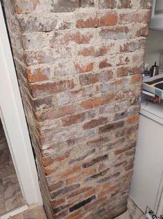 an old brick wall in the corner of a kitchen