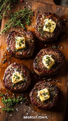 four steaks with cheese and herbs on a cutting board