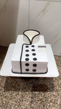 a cake shaped like a domino board on top of a white plate with black dots