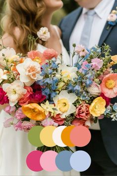 a bride and groom are kissing in front of the camera with their colorful bouquets