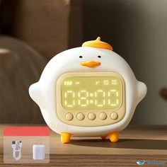 an alarm clock with a penguin face on it's face, sitting on a table