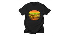 a black t - shirt with an orange and green sunset on the ocean in front of it