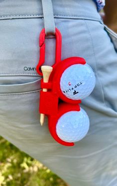 a golf ball holder is attached to the back of a man's pants