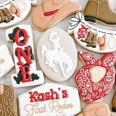 some cookies that are decorated like cowboy hats and boots with the words kosh's first rodeo written on them