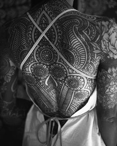 the back of a man with tattoos on his body