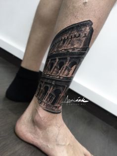 a man's leg with a tattoo on it that has an image of the colossion