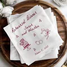 three wedding napkins on top of a wooden plate