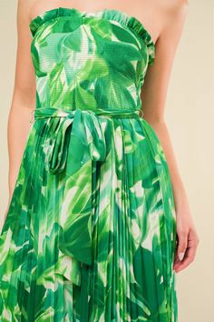 A printed woven jumpsuit featuring strapless, smocked bodice with ruffled edge, self sash, pleated pant with wide leg Details: Self : 100% PolyesterLining : 100% Polyester Size & Fit - Model is 5`8" And Wearing Size Small- Measurements Taken From Size Small- Approx. length: 55" Green Sleeveless Dress With Elastic Waistband, Green Smocked Back Jumpsuits For Spring, Green Smocked Back Jumpsuit For Summer, Green Smocked Back Jumpsuit For Vacation, Green Vacation Jumpsuits With Smocked Back, Green Vacation Jumpsuits And Rompers With Smocked Back, Green Jumpsuits And Rompers With Smocked Back For Vacation, Casual Green Strapless Jumpsuits And Rompers, Sleeveless Pleated Jumpsuits And Rompers For Spring