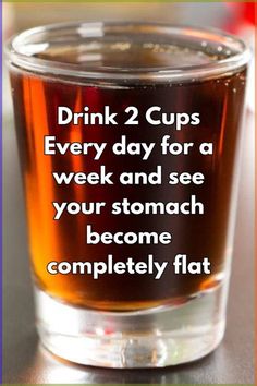 a glass filled with liquid sitting on top of a table next to a sign that says drink 2 cups every day for a week and see your stomach become completely flat