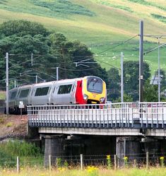 a yellow and red train traveling over a bridge