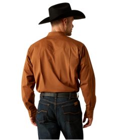 Embrace your inner cowboy with the Ariat Mens Relentless Pursuit Classic Fit Shirt. Featuring pearl snaps, this shirt offers a classic fit that is ready for the rodeo or the dance floor. Make a statement with this stylish and durable shirt that is perfect for any true cowboy's wardrobe. Ride in style and comfort with Ariat. Material: 98% Cotton / 2% Elastane Western Style Relaxed Fit Shirt With Button Closure, Fitted Brown Shirt For Rodeo, Fitted Western Brown Shirt, Brown Fitted Western Shirt, Fitted Brown Western Shirt, Western Brown Shirt For Ranch, Western Style Brown Shirt For Ranch, Brown Western Shirt For Ranch, Western Style Brown Tops For Ranch