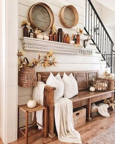 a wooden bench sitting under a stair case next to a wall filled with pumpkins