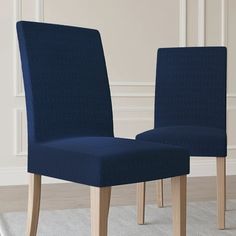 two blue chairs sitting side by side in a room with white carpet and wooden floors