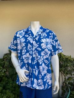 Vintage button up Hawaiian shirt by Oceanaire.  Blue and white hibiscus print.  Buttons down the front.  Excellent vintage condition - fabric is nice and crisp and feels unworn. label:  Oceanaire made in USA fabric:  polyester/cotton blend size:  tag says XL.  Modern size L is just an estimate.  Please check measurements for an accurate fit.  Questions are welcome! shirt was measured across the front side lying flat underarm to underarm 26 1/2" length 29" shoulder 20 1/2" Classic Blue Tops For Vacation, Tropical Floral Print Short Sleeve Shirt For Vacation, Classic Blue Tops For Beach, Classic Blue Shirt For Vacation, White Floral Print Hawaiian Shirt With Relaxed Fit, Blue Hawaiian Shirt With Hibiscus Print For Beach, Blue Hibiscus Print Camp Shirt For Vacation, Relaxed Fit Hawaiian Short Sleeve Shirt With Floral Print, White Collared Hawaiian Shirt For Vacation