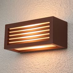 an outdoor wall light with wooden slats on the outside and white walls behind it