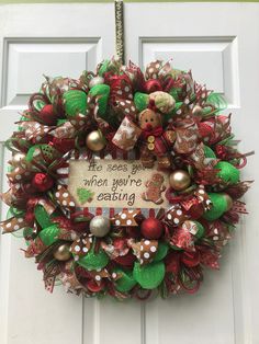 a christmas wreath that says, the season is when you're eating and decorated with ornaments