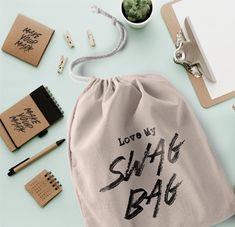 a drawsack bag with the words love my swag bag written on it next to various office supplies