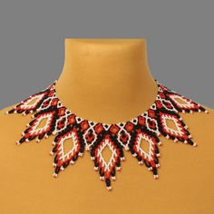 a red and black beaded necklace on top of a mannequin neckline