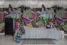 a bedroom with graffiti on the walls and a bed in front of a wall mounted skateboard