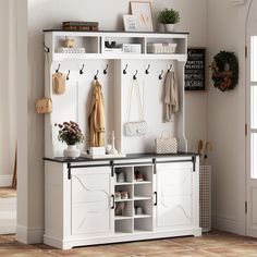 a white coat rack with shoes and purses hanging on the wall next to it