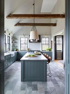 a kitchen with blue cabinets and an island in the middle, along with lots of counter space