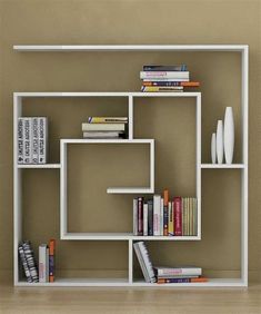 a book shelf with books and other items on it in a room that is painted beige