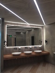 a bathroom with three sinks and two mirrors