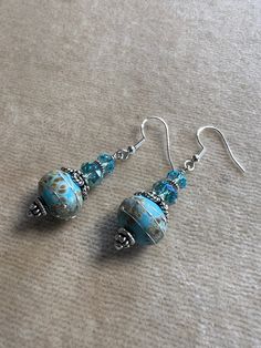 Artisan lampwork beads in turquoise blue with sterling silver stringers 11mm x 13.6mm apx, framed with elegant silver bead caps, spacers, and Swarovski crystals 6mm on top, sterling silver spacer and Swarovski crystal 7.5mm below, wire wrapped onto decorative Bali sterling silver earwires.  These earrings measure 2 1/8" from the top of the earwire. * * * * Shipping and Returns * * * *  All items will be shipped in 1 - 2 days.  Your satisfaction is guaranteed. If you are unhappy with your purchase for any reason, you may return it within 10 days for a full refund (less shipping costs). Adjustable Light Blue Jewelry With Spacer Beads, Turquoise Czech Glass Jewelry With Spacer Beads, Turquoise Czech Glass Round Beads Jewelry, Turquoise Czech Glass Bead Jewelry, Silver Czech Glass Beaded Round Earrings, Silver Czech Glass Beaded Earrings, Turquoise Czech Glass Round Jewelry, Nickel-free Czech Glass Artisan Jewelry, Artisan Nickel-free Czech Glass Jewelry