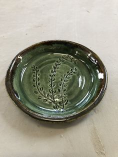 a green plate with small leaves on it